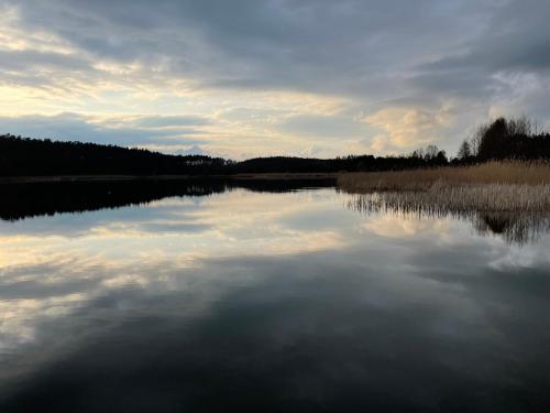 a large body of water with a cloudy sky at Domki nad jeziorem w Borach Tucholskich in Skorzenno