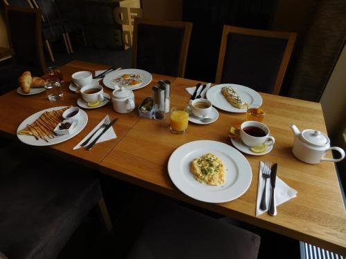 a wooden table with plates of food on it at Penzion Eden in Pec pod Sněžkou