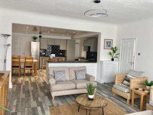 a living room with a couch and a kitchen at A wave from it all in Blackpool