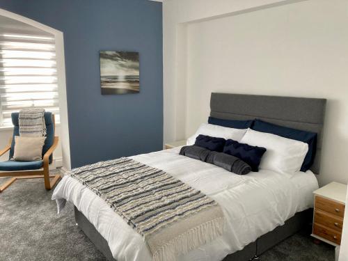 a bedroom with a large bed and a chair at A wave from it all in Blackpool