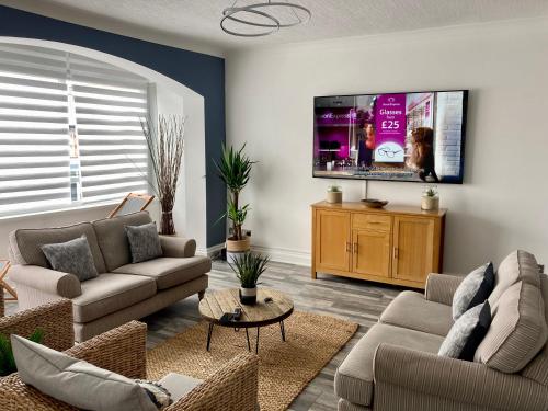 a living room with two couches and a flat screen tv at A wave from it all in Blackpool