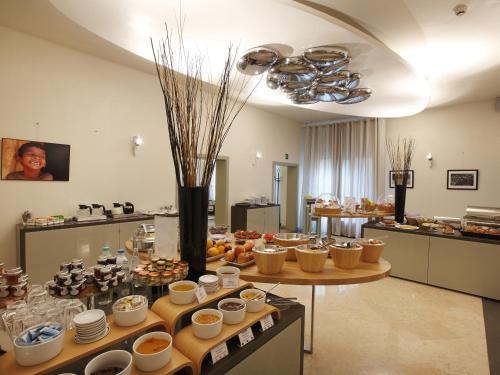a large kitchen with a table with bowls and cups at Hotel Annunziata in Ferrara