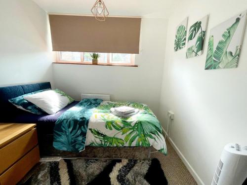 a small bedroom with a bed and a window at 5min Drive to Luton Airport, 2 Train Stations & Motorway - FREE PARKING - LATE CHECK OUT 11AM - Quiet & Peaceful Location with a relaxing Garden - ONLY 25min drive to North LONDON - FREE WIFI in Luton