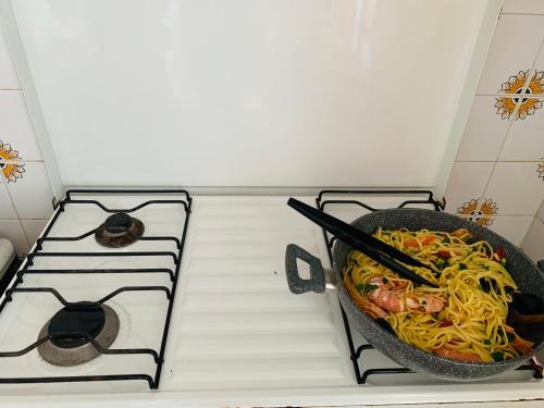 a pot of noodles on a stove in a kitchen at VistaMare in San Foca