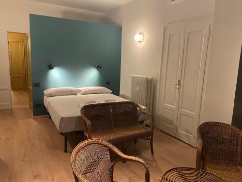 - une chambre avec un lit et deux chaises dans l'établissement Ritorno alle origini Suites, à Milan