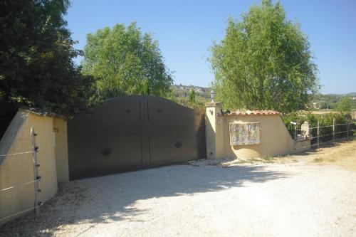 a garage with a large gate in a driveway at Lou mas li Pitchoun "L'olivade" in Gordes