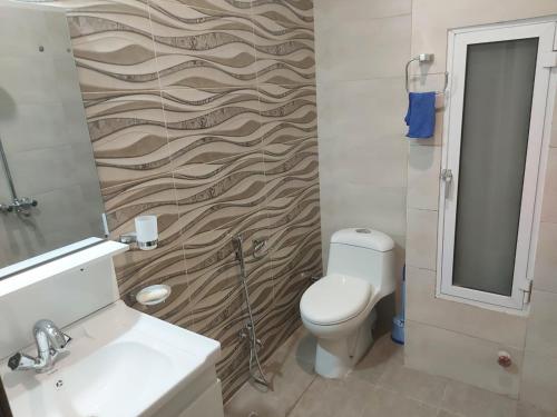 ein Badezimmer mit einem WC, einem Waschbecken und einem Spiegel in der Unterkunft The River View Apartment in Rawalpindi