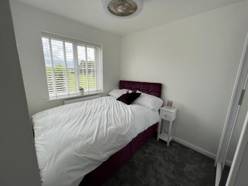a bedroom with a bed with white sheets and a window at Luxury 4 bedroom Retreat; with hot tub & parking in Birmingham