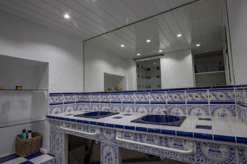 - une salle de bains bleue et blanche avec deux lavabos et un miroir dans l'établissement La Marinade, à Banyuls-sur-Mer