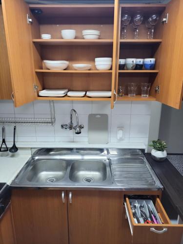 a kitchen with a sink and wooden cabinets at Newly renovated spacious 2 bedroom unit in HBC in Seoul