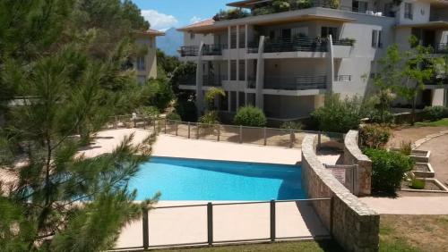 une villa avec piscine devant un immeuble dans l'établissement Maria stella, à Calvi