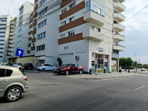 een straat met auto's geparkeerd voor een gebouw bij Garsoniera 1 decembrie in Alba Iulia