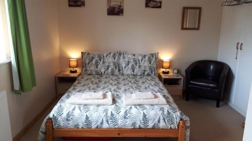 ein Schlafzimmer mit einem Bett mit zwei Handtüchern darauf in der Unterkunft Pendine Sands Guest House in Pendine