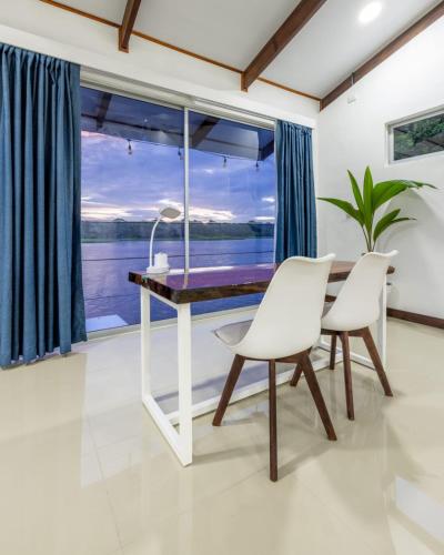 a dining room with a table and chairs and a large window at The Babylon Suite Tortuguero in Tortuguero