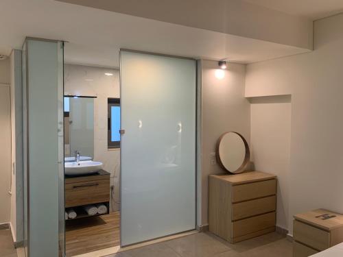 a bathroom with a shower and a sink and a mirror at Lavender Villas Agios Nikitas , Lefkada in Agios Nikitas