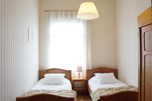 two beds in a room with a window at Hotel Boutique Casa Werner in Puerto Varas