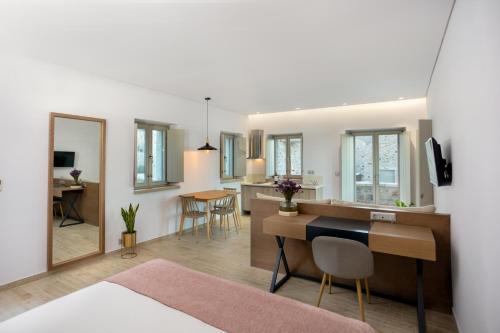 a living room and kitchen with a desk and a dining room at Armantanis Luxury Suites in Areopolis