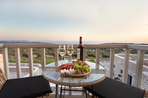 a table with two glasses of wine and a bowl of fruit at Armantanis Luxury Suites in Areopolis