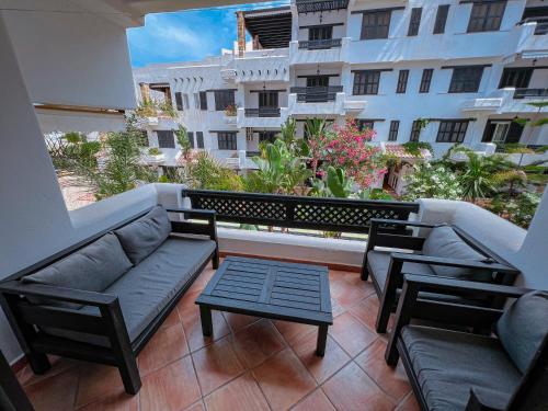 un balcón con sofás y una mesa y un edificio en Visit Oued Laou - Jawhara, en Oued Laou