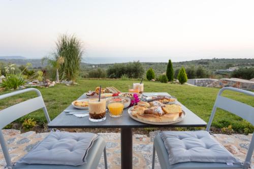 a table with a plate of food and drinks at Armantanis Luxury Suites in Areopolis