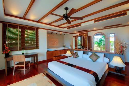 sypialnia z dużym białym łóżkiem i biurkiem w obiekcie Patong Seaview Luxury Villa Penda w Patong Beach