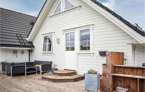 a white house with a deck and a patio at 4 Bedroom Gorgeous Home In Herdla in Herlø