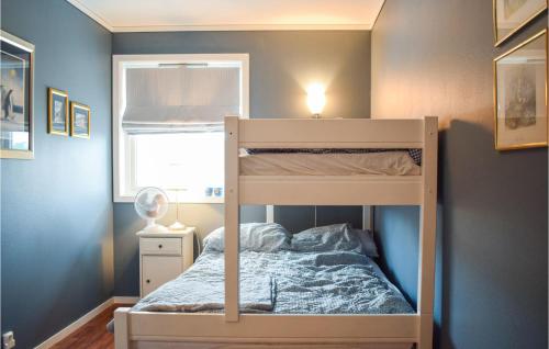 a bunk bed in a bedroom with a blue wall at 4 Bedroom Gorgeous Home In Herdla in Herlø