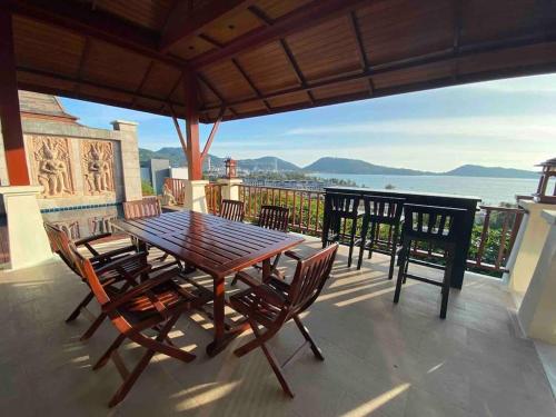 a table and chairs on a balcony with a view of the ocean at Patong Seaview Luxury Villa Penda in Patong Beach