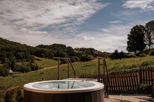 a hot tub in a field with a fence at Schlössl Hotel Kindl in Bad Gleichenberg