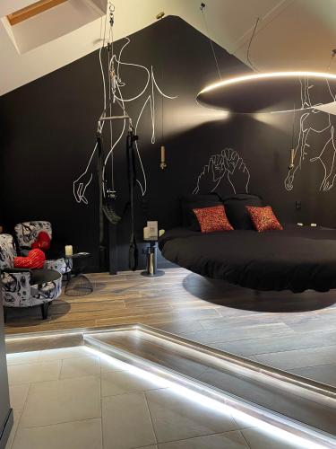 - une chambre avec un lit et un mur noir dans l'établissement Luxe and Spa, à Condé-Sainte-Libiaire