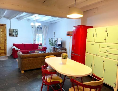 un soggiorno con tavolo e frigorifero rosso di Los Cuatro Cantones - Con BARBACOA a Ariza