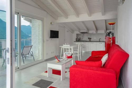 a living room with a red couch and a table at OLEANDRA ROSSA in Nesso