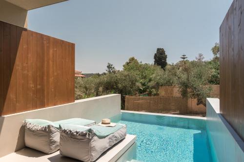 a swimming pool with a tub and a chair at Lazaros Hotel Resort in Tsilivi