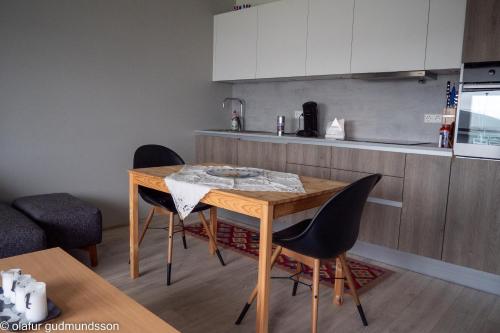 a kitchen with a wooden table and two chairs at Comfortable apartment in Vogar