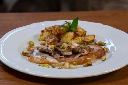 a plate of food with meat and potatoes on a table at Agriturismo Masseria Cannella in Lesina