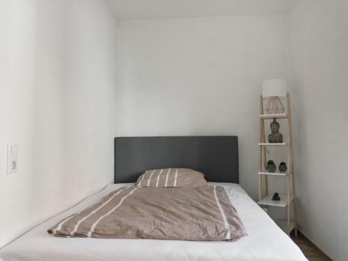 a bed with a gray headboard in a bedroom at Helles Studio in Innenstadt mit Netflix in Mannheim