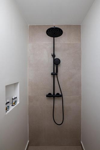 a shower in a bathroom with a shower head at Blue Gres Villa Tinos in Tinos Town