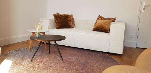 a living room with a white couch and a table at Appart POP 1 Centre ville calme avec parking in Arras