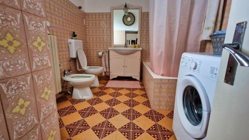 ein Badezimmer mit einem WC und einer Waschmaschine in der Unterkunft A quai a Chiara in Andrano