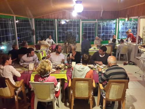 a group of people sitting at tables eating food at Rose Hotel B&B in Patara