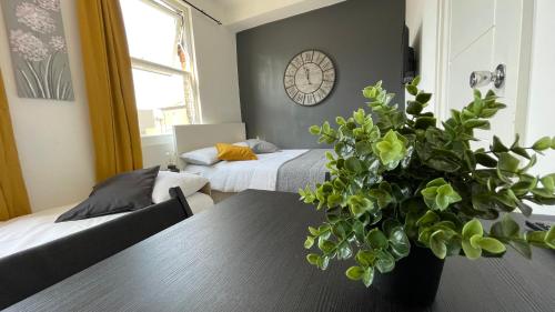 a living room with a table with a plant at Lovely studio flat in the heart of Holloway. in London