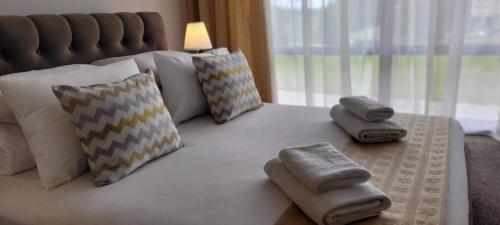 a large white bed with pillows and towels on it at Hotel Angelas in Utena