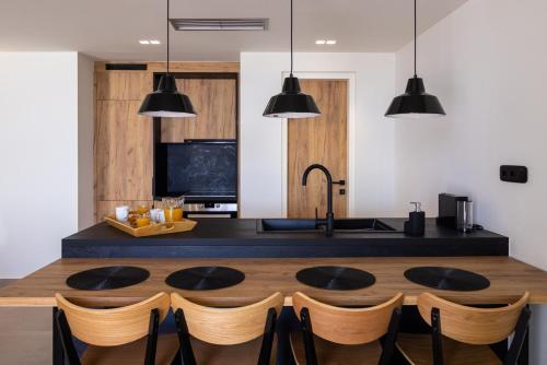 a kitchen with a table with chairs and a sink at Blue Gres Villa Tinos in Tinos Town