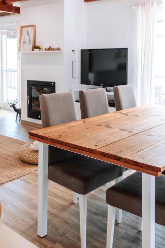 a dining room with a wooden table and chairs at Pura - Home in Nature in Oliveira do Hospital
