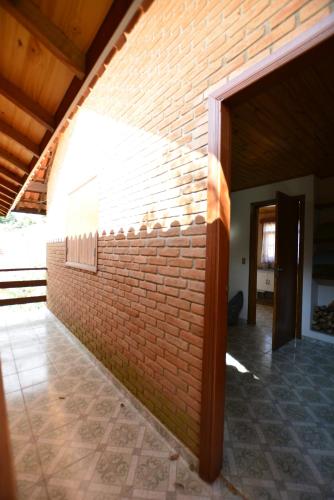 a brick wall with an open door in a building at Pousada Cantinho Colibri in Monte Verde