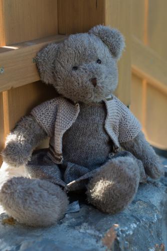 a brown teddy bear sitting on a rock at Holiday Home Planina in Tržič