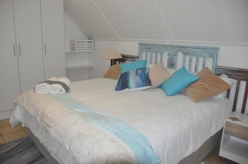 a bedroom with a white bed with pillows at Smartie Box in Langebaan