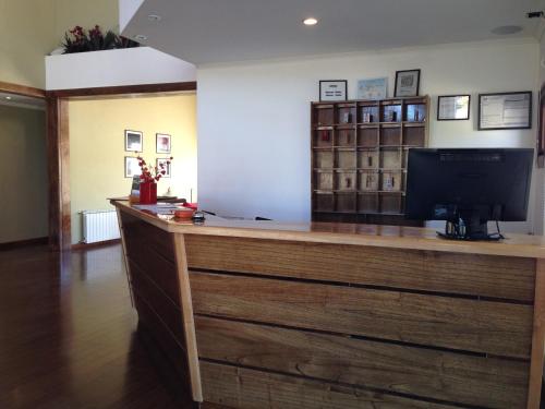 a reception desk with a television on top of it at Hotel Poincenot in El Chalten