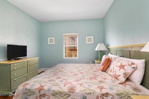 a bedroom with a bed with a dresser and a television at Spacious, cozy 2brd /2bath condo - LakeTown Wharf in Panama City Beach