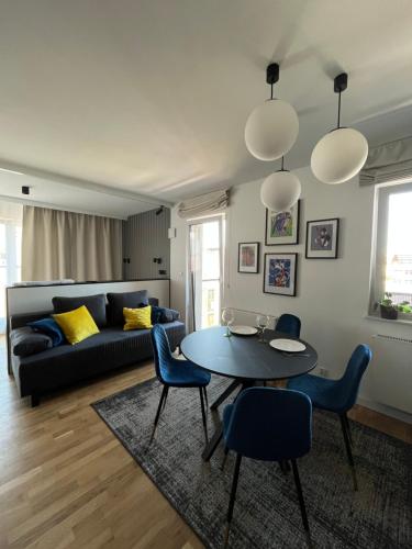 a living room with a table and chairs and a couch at Halo Apartments in Wrocław